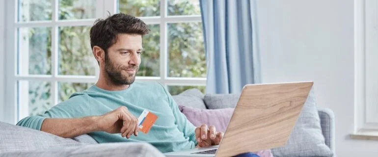 Man paying with a credit card on his laptop