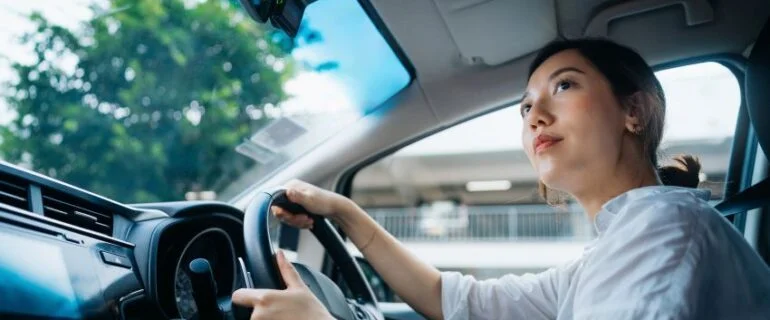 Young woman driving a car in the city