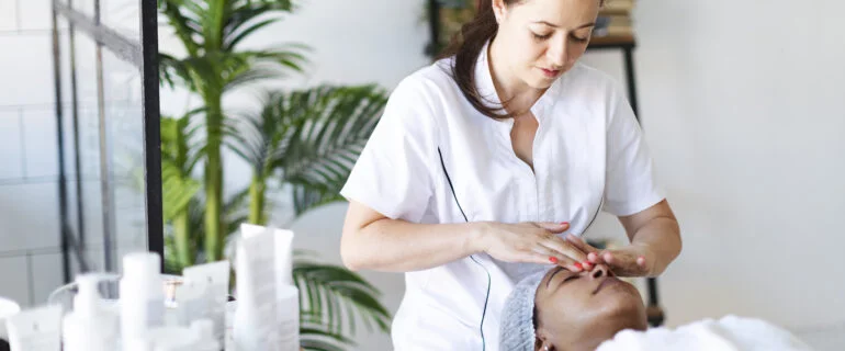 Cosmetologist doing a face massage at home
