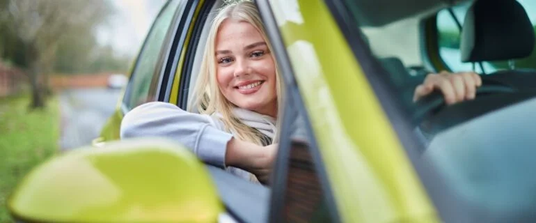 Young woman looking out of a car window as she is driving