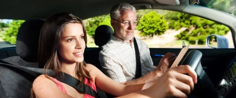 Learner driver student driving car with instructor