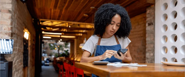 Black female business leader using online banking on mobile device